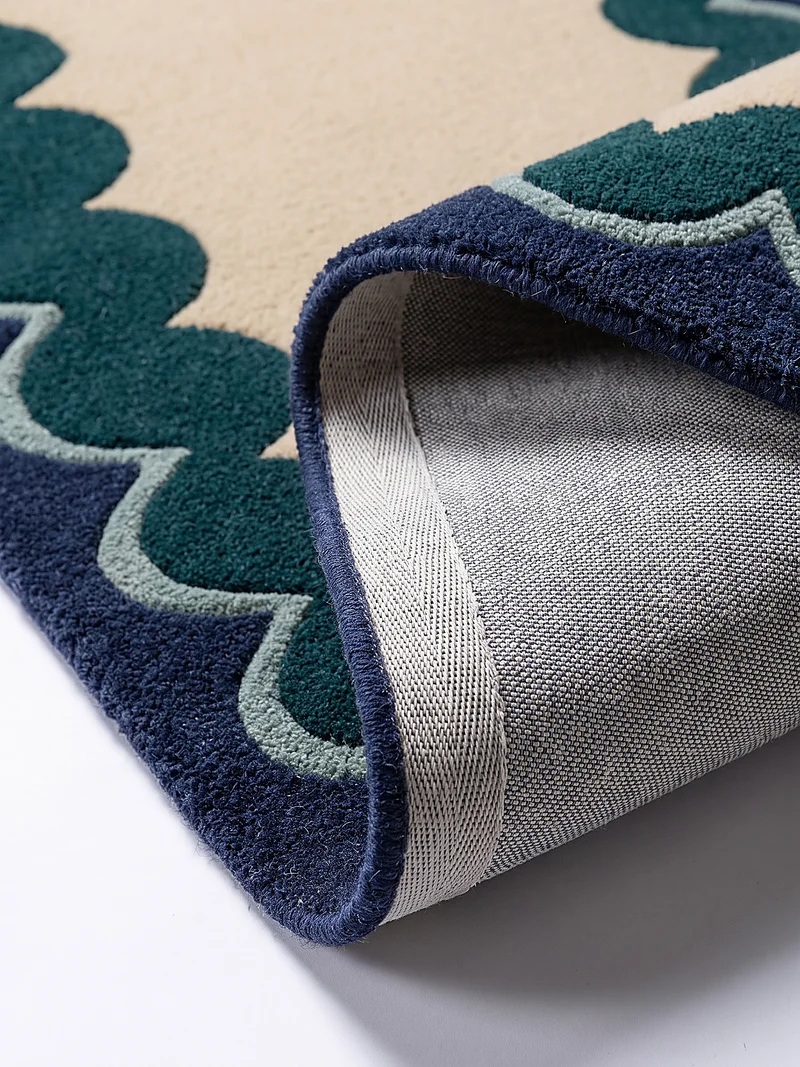 Wollteppich mit Wellenrand · handgetuftet, 5 mm Flor · 3.250 g/m²